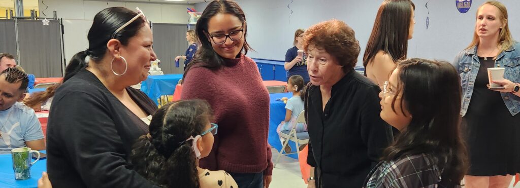 Three women talk to a young girl