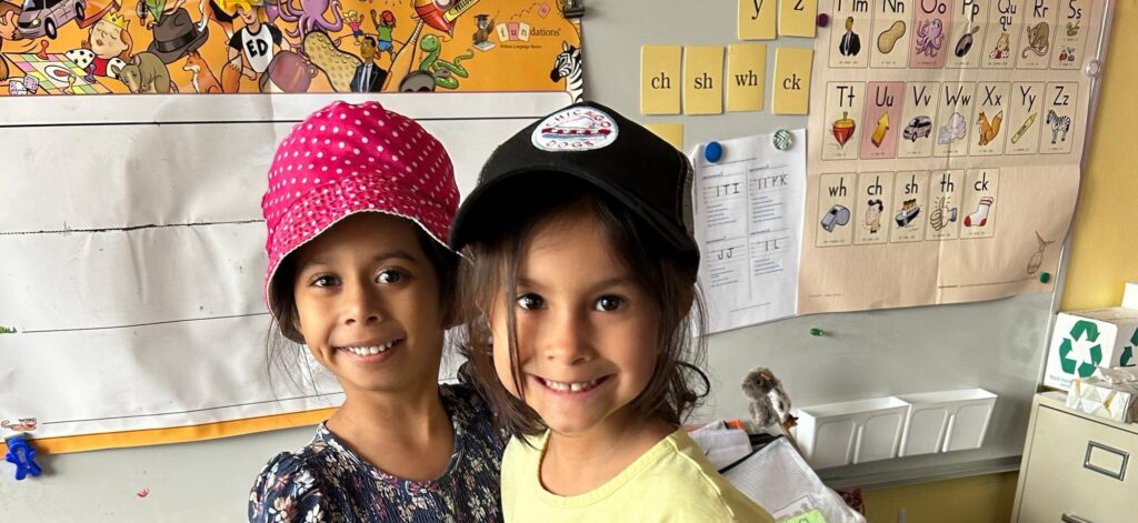 Two young girls in hats smiling