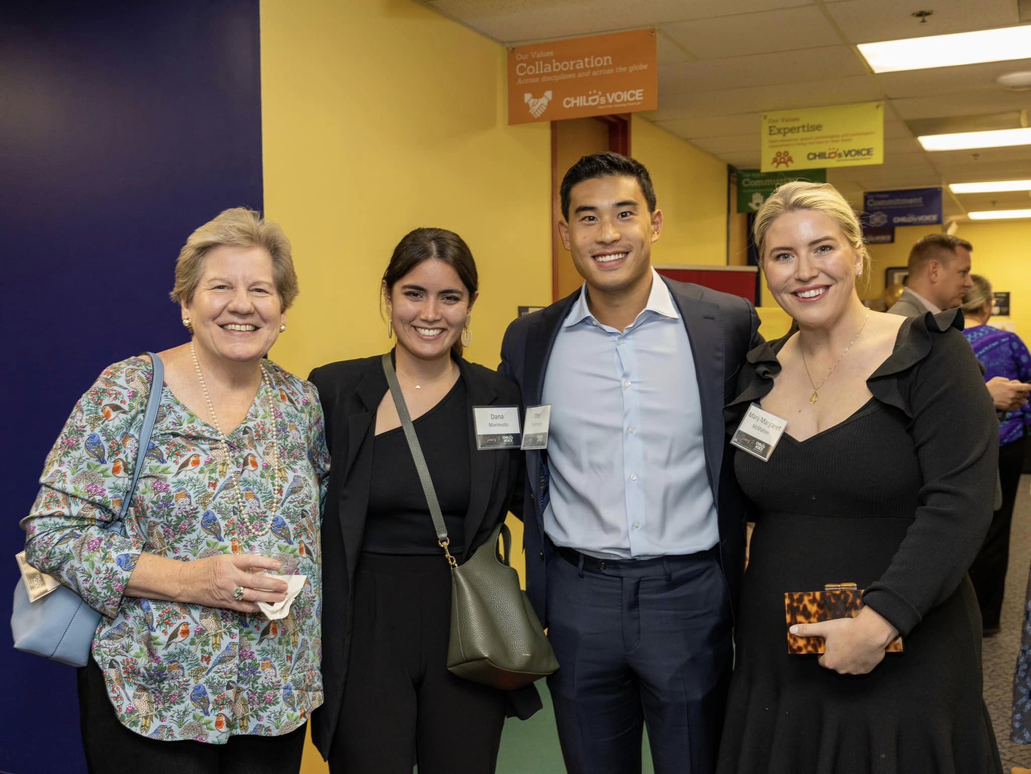 Four people smile at a party