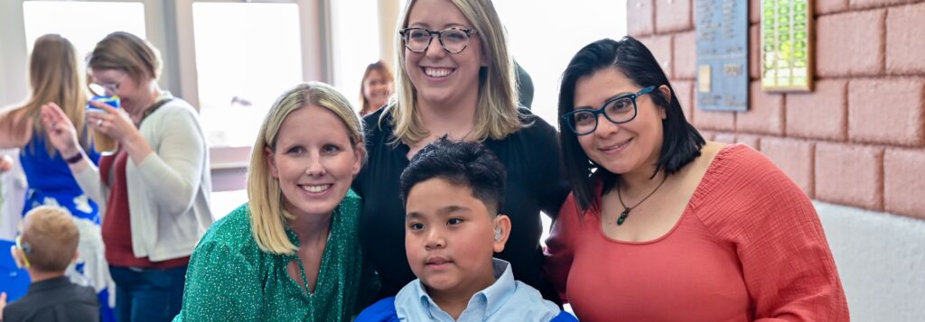 Three woman smile with a young boy