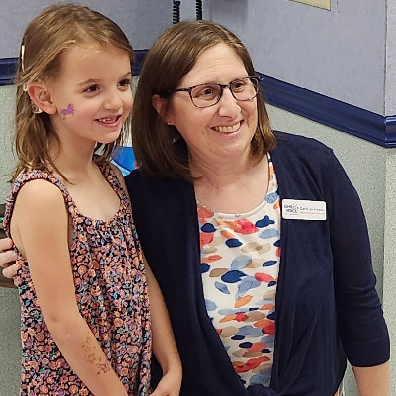 A young girl and a woman smile