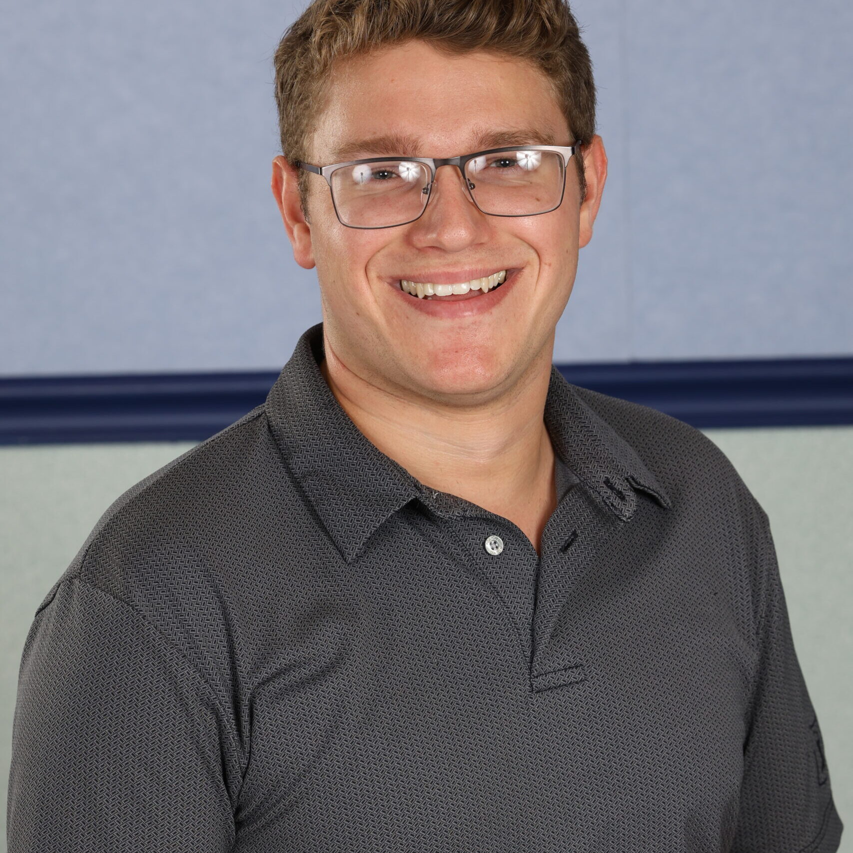 Man with glasses in a grey shirt